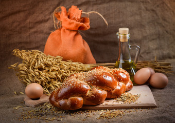 still life of bread and millet in old style on a linen cloth with a distinct texture. The figure also oil and grain cereals and eggs.