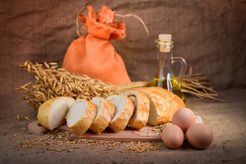 still life of bread and millet in old style on a linen cloth with a distinct texture. The figure also oil and grain cereals and eggs.