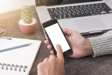 Business hand holding smart phone with white screen isolated on desk office background.
