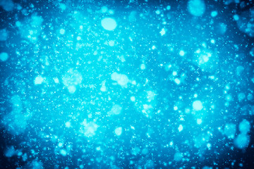 Abstract bokeh or glitter lights on blue  background. Circles and defocused particles. Design template