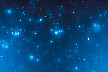 Fototapeta premium Abstract bokeh or glitter lights on blue background. Circles and defocused particles. Design template