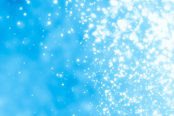 Abstract bokeh or glitter lights on blue  background. Circles and defocused particles. Design template