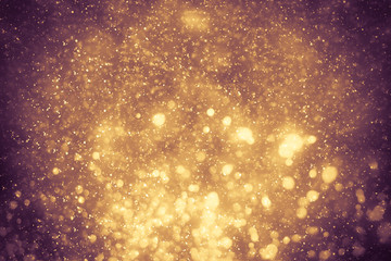 Fototapeta na wymiar Golden abstract sparkles or glitter lights. Festive gold background. Defocused circles bokeh or particles. Template for design