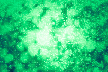 Fototapeta na wymiar Green abstract background. Bokeh or round defocused particles or glitter lights