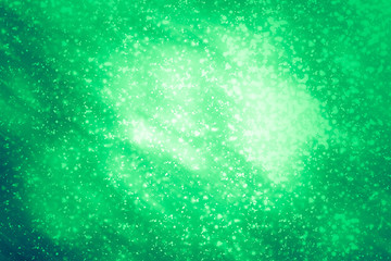 Fototapeta premium Green abstract background. Bokeh or round defocused particles or glitter lights