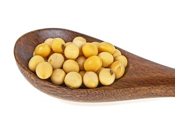 Soybeans in wooden spoon on a white background