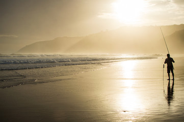 Fototapeta premium Fisherman with Fishing Rod Holder during Sunset at Wilderness Beach in South Africa