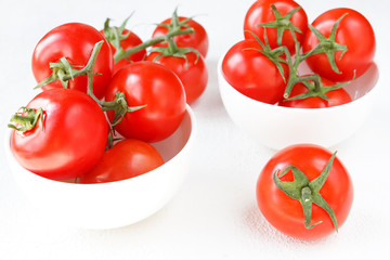Fresh tomato juicy on a branch close-up on a light background horizontal view top view