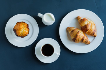 Breakfast. Coffee with milk muffin and croissants.
