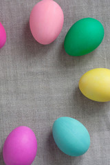 Close up circle of colored easter eggs laid on grey linen textured background. Easter web Banner. Group of colored painted eggs. Easter celebration concept. Template mock up with copy space for text.