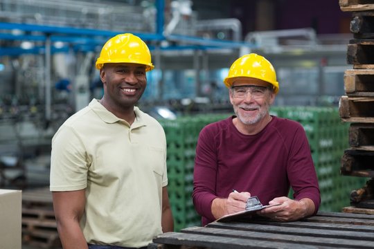 Two factory workers standing with clipboard 