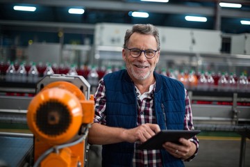 Portrait of factory worker standing with a tablet
