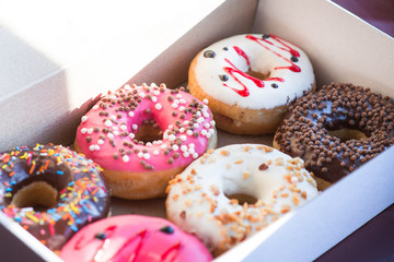 Colorful tasty glazed delicious doughnuts in the box