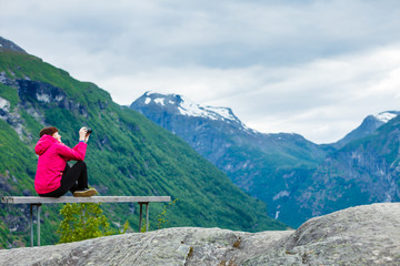 Fototapeta na wymiar Tourist with camera looking at scenic view in mountains Norway