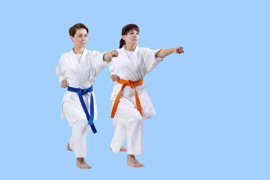 Adult girls in karategi are hitting punch arm