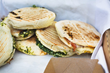 Street vendor selling pitas outdoors, closeup of wrapped snacks