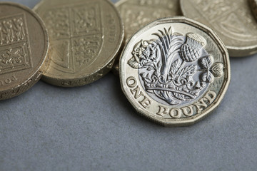 New British one pound coin alongside the old coin