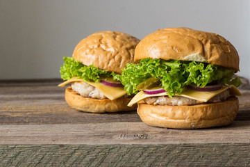 home made tasty burgers on wooden table.