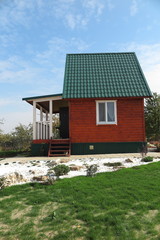 Modern summer cottage against a blue sky in the autumn garden