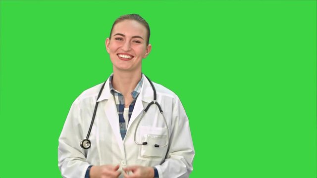 Smiling beautiful woman in lab coat talking to the camera on a Green Screen, Chroma Key.