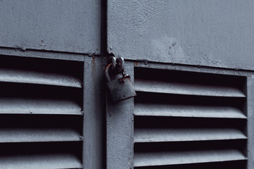 Closeup shot of metal lock hanging on a ventilation shaft