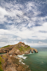 Fototapeta na wymiar View from the coast on the rock in the ocean with a chapel Doniene Gaztelugatxeko