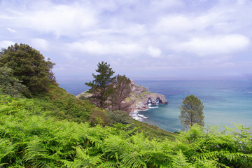 Fototapeta na wymiar View from the coast on the rock in the ocean with a chapel Doniene Gaztelugatxeko