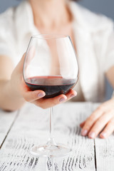 Female touching glass oа red wine