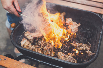 Grill steaks on metal grate with flame, barbecue