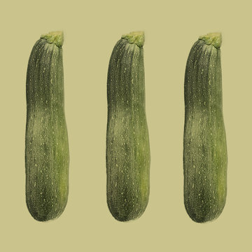 Three courgettes against plain background
