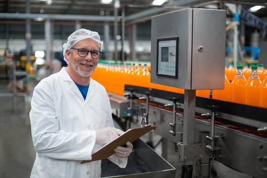 Factory engineer maintaining record on clipboard 