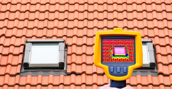 An infrared thermal imager showing roof window heat loss.