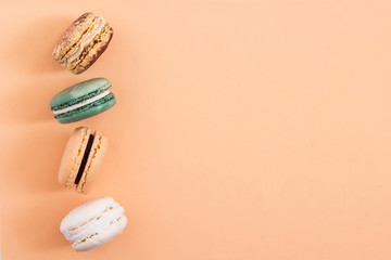 Row of colorful french macaroons on blue background. Top view, copy space for text. Social media, blogging concept 