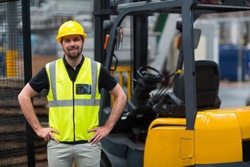 Factory worker standing with hand on hips in factory