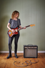 a young woman playing an electric guitar