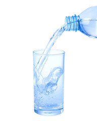 Pouring water from bottle into glass isolated on white background.