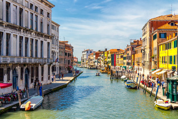 Fototapeta na wymiar View of the canal with boats and gondolas in Venice, Italy. Venice is a popular tourist destination of Europe