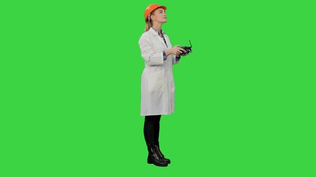 Female engineer correct parts of an object using remote controller on a Green Screen, Chroma Key.