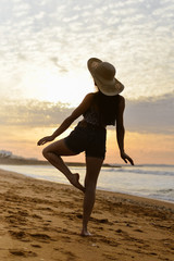 Fototapeta na wymiar Joyful woman dancing in the sunset on beach background