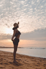 Joyful woman dancing in the sunset on beach background