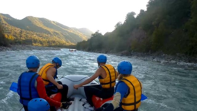 Team of experienced athletes sailing down the river on rafting boats, expedition