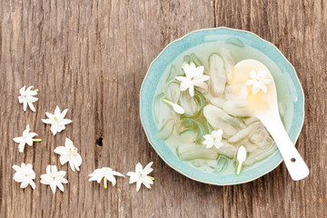 Fresh toddy palm fruit and bowl of Thai dessert on wood background