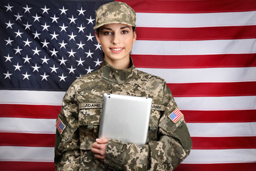 Female soldier with tablet on flag background