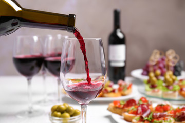 Pouring red wine into glass at lunch time
