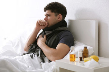 Obraz premium Young ill man in bed at home