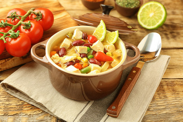 Chicken tortilla soup with vegetables on kitchen table