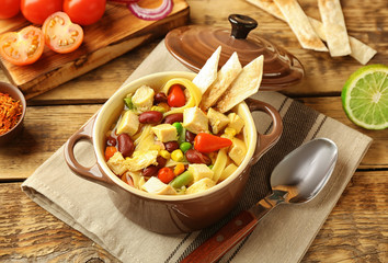 Chicken tortilla soup with vegetables on kitchen table