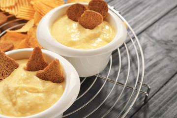 Bowls with beer cheese dip and toasts on metal stand