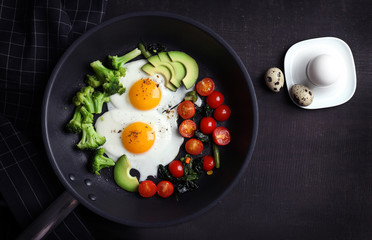 Pan with delicious roasted eggs and avocado on wooden background