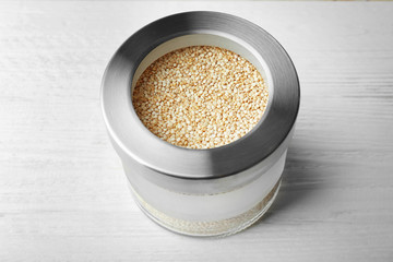 Jar with quinoa seeds on wooden table